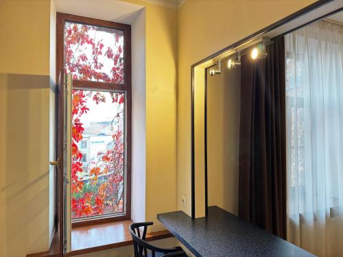 a room with a window and a table and a mirror at ApartHotel Riga in Rīga