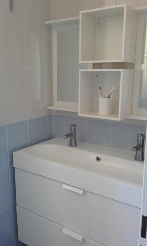 - un lavabo blanc avec deux robinets dans la salle de bains dans l'établissement maison récente proche forêt et bord de mer, à Saint-Jean-de-Monts