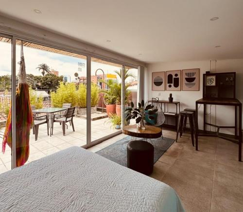 a bedroom with a bed and a kitchen and a patio at Moonshine Boutique Hostal in Cali