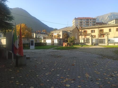 a street in a town with buildings and a flag at Casa Stella Terminal in Perosa Argentina