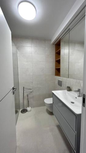 a white bathroom with a sink and a toilet at The Comfy Nest - Parking, King Size Bed, Smart Tv in Cluj-Napoca