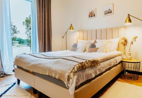 a bedroom with a large bed and a large window at Marina Relax - widok na jezioro, parking podziemny, winda, Netflix, TV55" in Iława