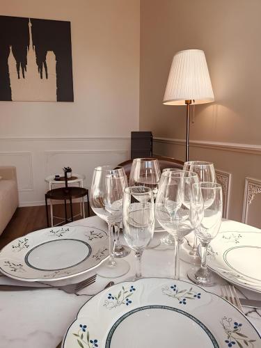 - une table avec des verres à vin et des assiettes dans l'établissement St Croix Appartement style Haussmannien lumineux 