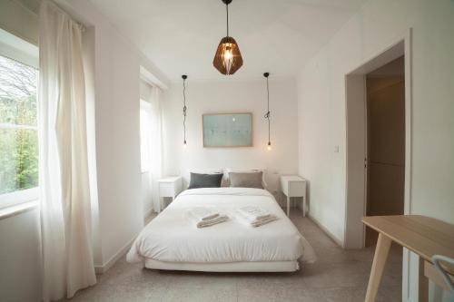 um quarto branco com uma cama e uma janela em FLH Estrela Comfortable Flat em Lisboa
