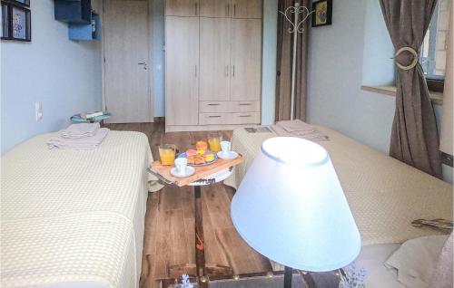 a room with two beds and a table with a lamp at Maison Elia With Private Pool in Kardamili