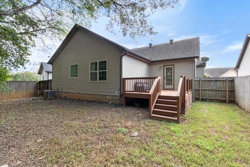 a house with a wooden deck in the yard at The Gate 4 Getaway! in Oak Grove