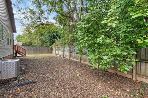 a fence in front of a house with a tree at The Gate 4 Getaway! in Oak Grove