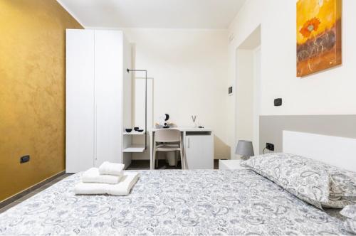 a white bedroom with a bed and a desk at Affittacamere Melara in Serre