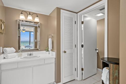 a white bathroom with a sink and a mirror at Sandpiper Beacon Beach Resort in Panama City Beach