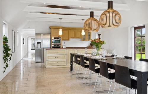 a kitchen with a long table and black chairs at Stunning Home In Otterup With Kitchen in Otterup