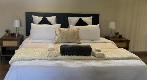 a large white bed with towels on it at Joy's Place - Fourways BnB in Sandton