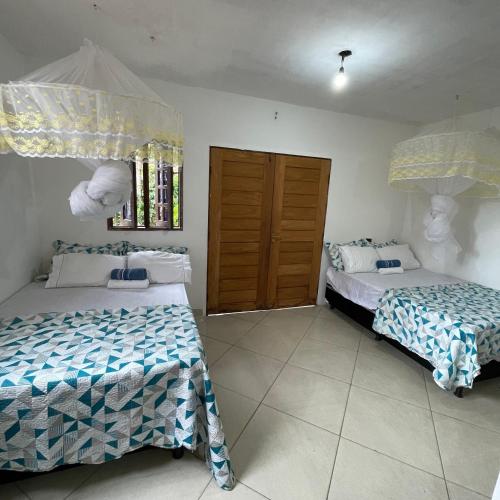 a bedroom with two beds and a window at KitNet em Caraíva-Nova Caraíva in Caraíva