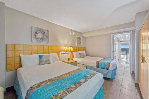 a hotel room with two beds and a balcony at WINTER RATES! Impeccable Oceanfront Suite, Top Floor! L1543 in Myrtle Beach