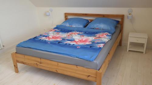 1 cama con edredón azul y almohadas azules en Teraz Karpacz, en Karpacz