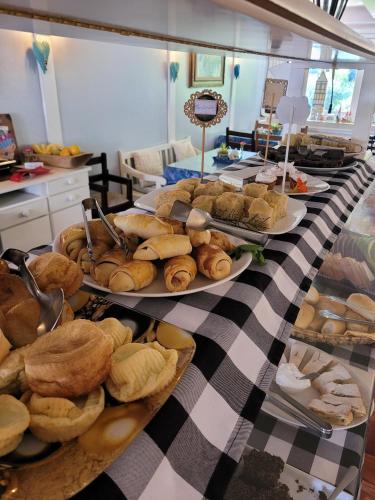 a table topped with plates of bread and pastries at Pousada Betânia in Gramado