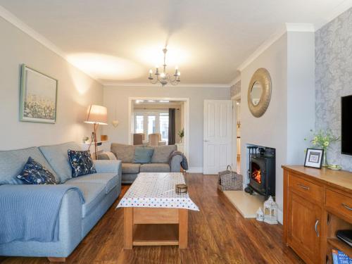 a living room with a blue couch and a fireplace at Hide and Sleep in Walton-on-the-Naze
