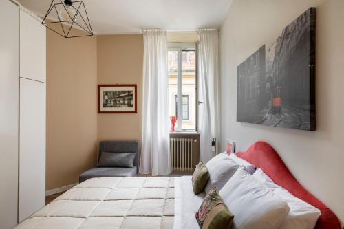 a bedroom with a bed and a chair and a window at Volta Accomodation in Milan