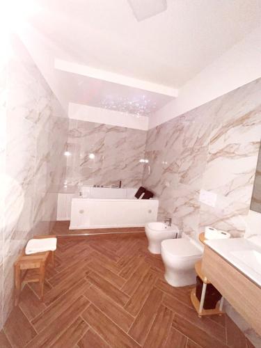 a bathroom with a tub and a toilet and a sink at Le Suite del Lungomare in Taranto