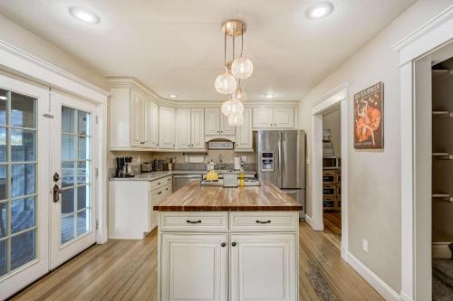 a kitchen with white cabinets and a large island at Bristhol Bloom! Oasis in the Heart of COS! in Colorado Springs