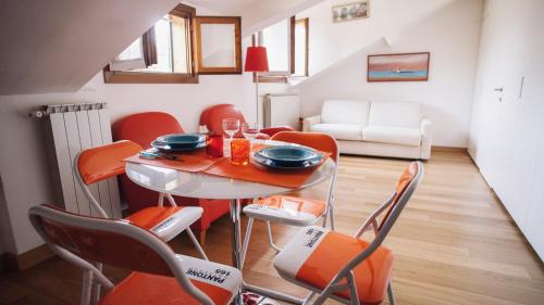 ミラノにあるItalianway-Vivaioのダイニングルーム(オレンジの椅子、テーブル付)