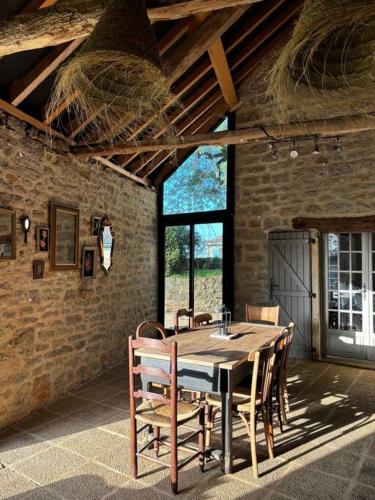 une salle à manger avec une table et des chaises en bois dans l'établissement Charmante Ferme Rénovée Piscine, à Caylus