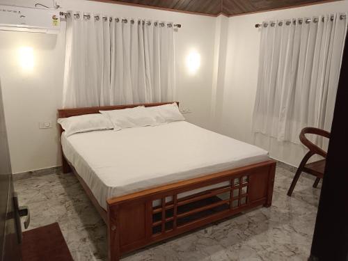 Posto letto in una piccola camera con sedia di ANGEL homestay kochi a Cochin