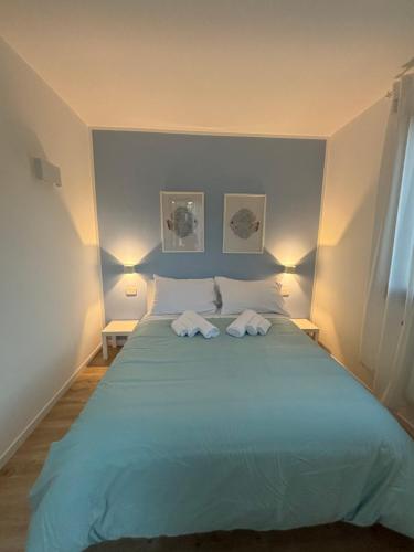 a bedroom with a large bed with two towels on it at Luminoso alloggio sul mare in Cattolica