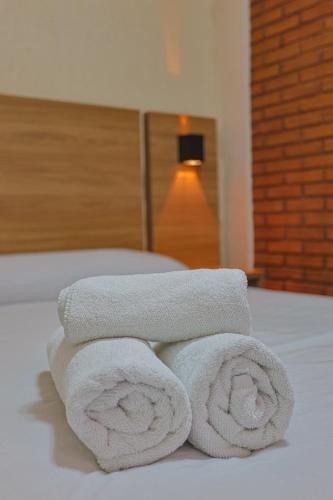 a pile of towels sitting on top of a bed at Hotel Garnier in Campos do Jordão