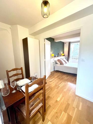 a dining room with a table and a bedroom at Petit appartement centre historique Laval in Laval