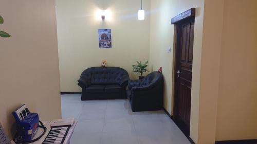 a waiting room with two chairs and a door at CANAAN MUSIC Hotel in Moratuwa