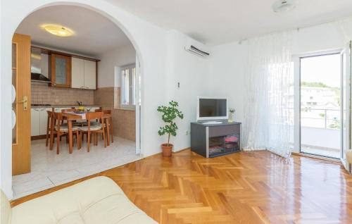 salon z drewnianą podłogą i jadalnią w obiekcie Apartment Komoseva I w mieście Mali Iž