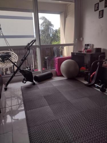 une salle de sport avec un tapis de course et un bureau dans l'établissement Le Brossolette 3, à Saint-Denis