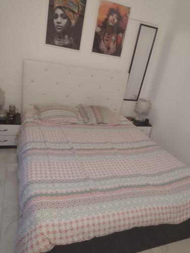 - un lit dans une chambre avec des affiches murales dans l'établissement Le Brossolette 3, à Saint-Denis