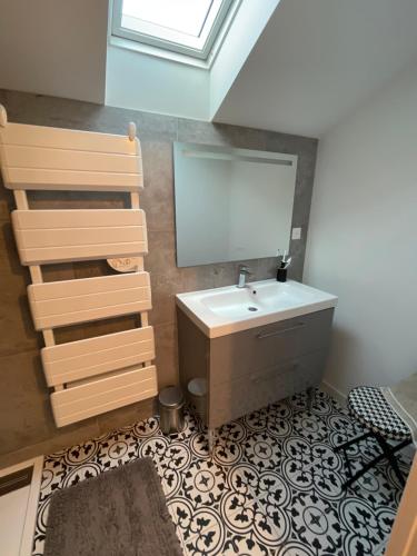une salle de bain avec un lavabo et un miroir dans l'établissement Appartement loft, à Châteaubriant