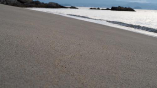 a sandy beach with the ocean in the background at ALFACIO RESORT STAY ITOSHIMA in Itoshima