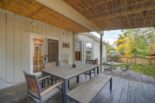 a porch with a wooden table and benches on a deck at Bristhol Bloom! Oasis in the Heart of COS! in Colorado Springs