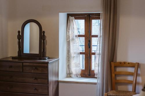 a bedroom with a dresser and a mirror and a window at Ariadni Cottage in Vasa