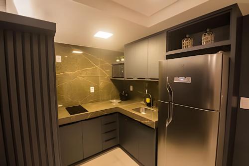 a kitchen with a stainless steel refrigerator and a sink at Condomínio Ozean - Bessa in Tambaú