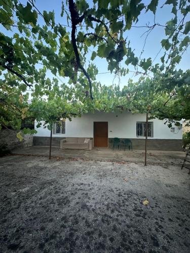 a white building with a door and two chairs at Aldi's house in Gjirokastër