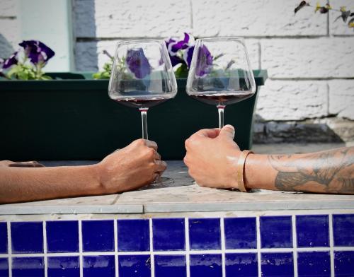 two people holding glasses of wine on a table at The Legacy BnB in East London