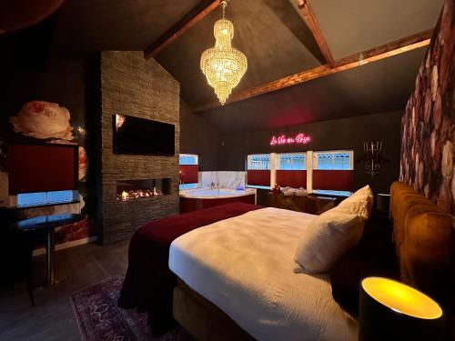 a bedroom with a large bed and a fireplace at Wellness Tuin - Boudoir Suite - Ultieme Partner Beleving met Jacuzzi en Openhaard en privé Sauna in Romantische stijl in Horst
