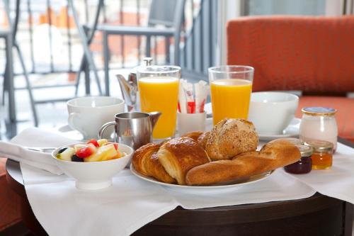 une table avec une assiette de pain et de jus d'orange dans l'établissement Le Senat, à Paris
