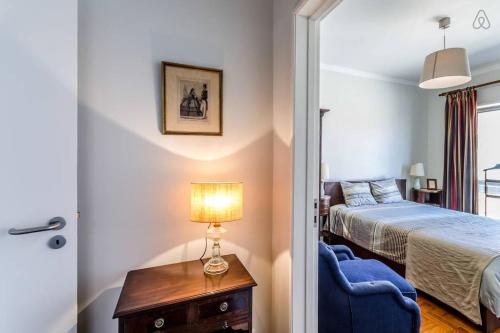 um quarto com uma cama e uma mesa com uma cadeira azul em Apartamento Com Vista Para O Mar no Porto