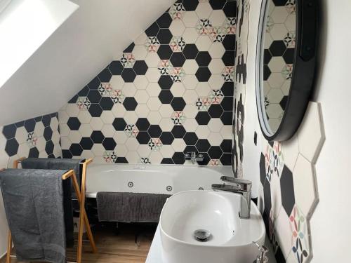a bathroom with a sink and a bath tub at Gîte le Beauchamp in Les Hautes-Rivières