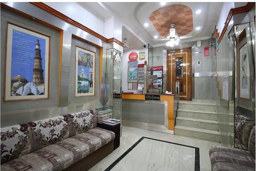 a lobby with a couch and stairs in a building at The C Park Inn Karol Bagh Homely Atmosphere in New Delhi