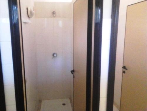 ein Bad mit einem WC und einer weißen Tür in der Unterkunft Nuraghe Ruiu Piazzole campeggio Blue Holiday in Norbello