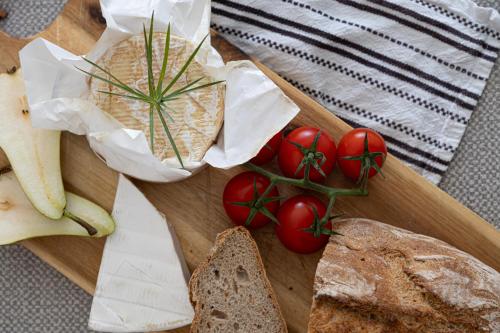 a wooden cutting board with tomatoes and bread on it at The Hayloft in Tiverton