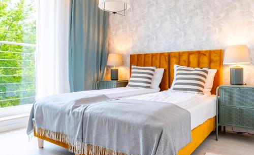 a bedroom with two beds and a window at Unique View Apartment - 3pok, 4 łóżka, widok na rzekę, centrum, Netflix, parking, winda in Iława