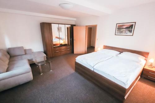 a bedroom with a bed and a couch at Amantis Vital Sport Hotel in Desná