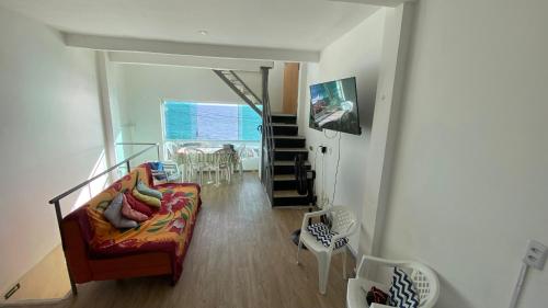 a living room with a couch and a stair case at Hostel Cantinho do Mar in Salvador